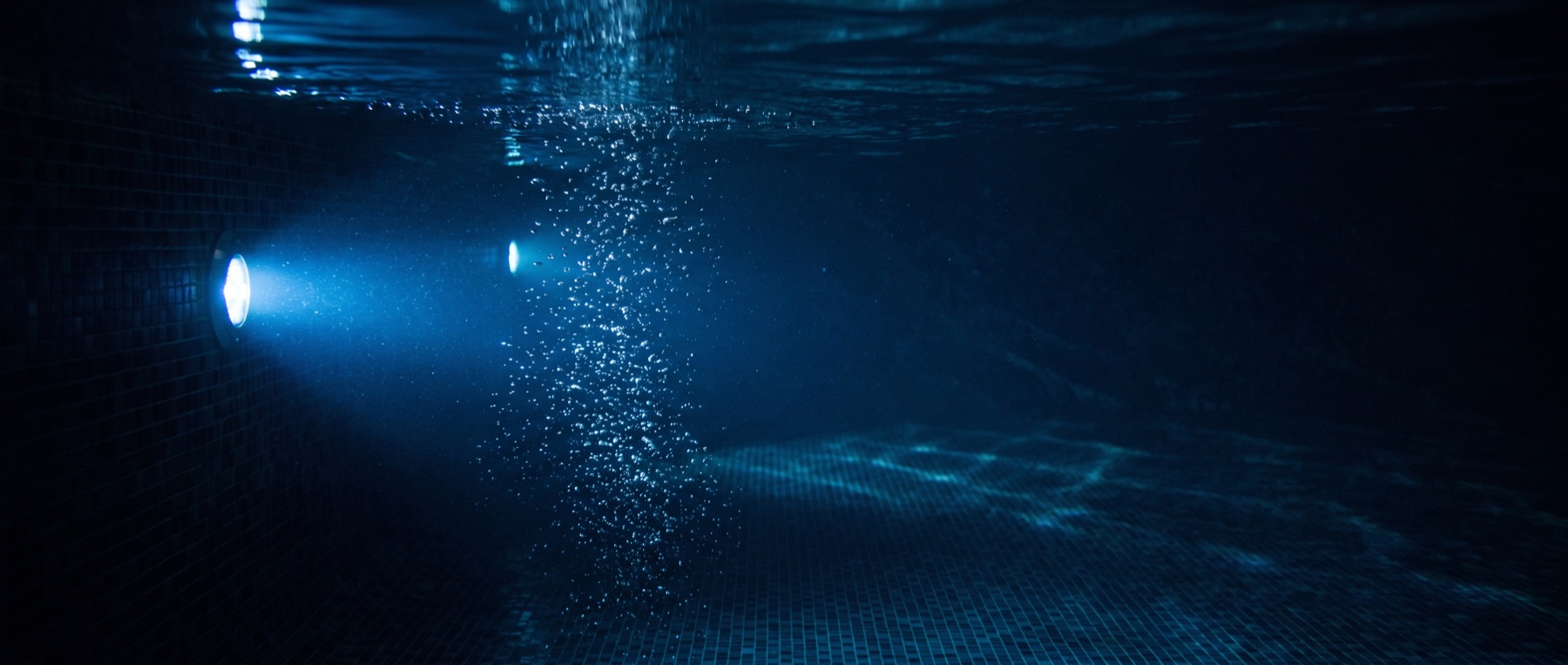 Clear pool water at night lit from below